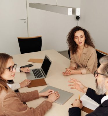 Professional team engaged in a meeting at a modern office table, discussing business strategies.