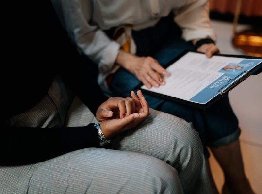 Two professionals reviewing a resume in an office setting, focused on teamwork.